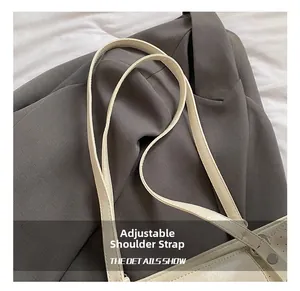 Detail view of adjustable shoulder strap with metal eyelets on cream tote bag