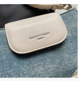 Detail of light blue denim fabric with silver rhinestones and beige leather texture