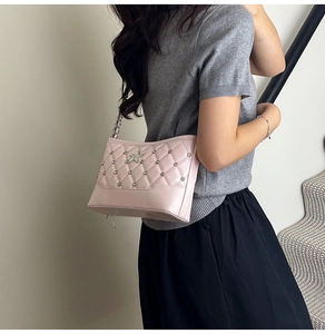 Close-up of pink quilted crossbody bag with silver star rhinestone and chain strap