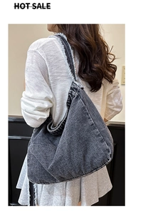 Dettaglio dei bordi sfilacciati della borsa hobo in denim grigio scuro con grande capacità