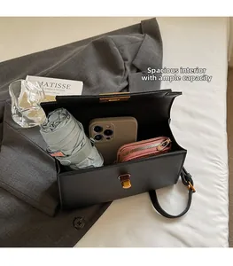 Interior capacity detail of black leather crossbody bag showing umbrella and phone
