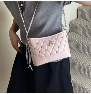 Detail of pink quilted bucket bag with rhinestone star and golden chain strap