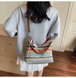 Détail du sac de plage tressé à rayures colorées avec bandoulière en cuir marron