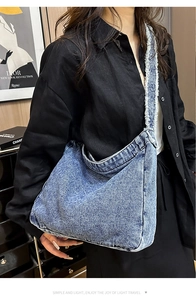 Dettaglio della borsa a spalla in denim con bordi sfilacciati ed effetto lavato vintage