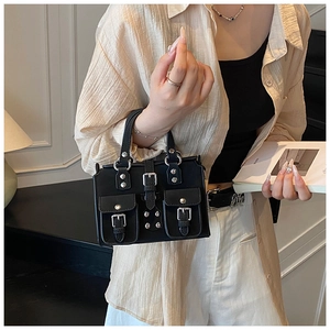 Close-up of black multi-pocket handbag with silver buckle details and leather texture