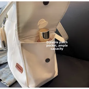 Detail of canvas tote side pocket with magnetic buckle showing storage capacity