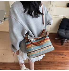 Détail du sac de plage tissé coloré avec breloque étoile et bandoulière en cuir brun