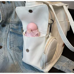 Detail of canvas tote side pocket with pink capsule umbrella and round coin purse