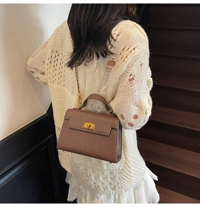 Brown litchi leather bag with gold twist lock and chain strap shown on a model
