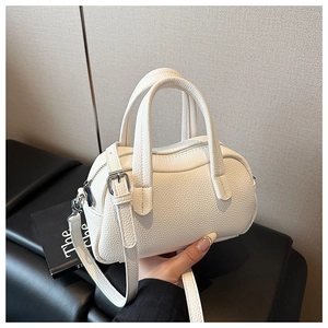 Détail de la texture cuir litchi blanc d'un sac à main élégant aux ferrures argent