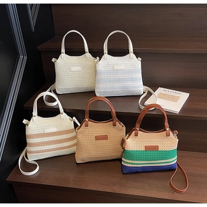 Close-up of assorted knit tote bags with leather handles on wooden stairs in a beach setting