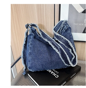 Dettaglio borsa a tracolla in denim blu con bordi sfrangiati e fibbia regolabile nera