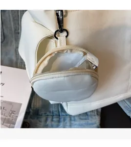 Detailed shot of white round canvas mini pouch with metal hook and zipper closure