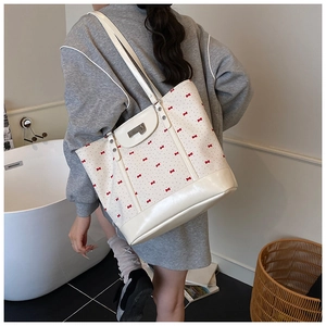 Floral cream tote bag with red bow pattern and leather base shown in a lifestyle setting