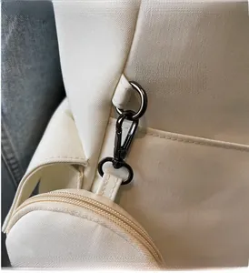 Detail of premium grey metal clasp and round coin pouch on canvas shoulder bag