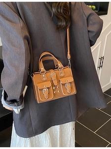 Retro brown motorcycle style handbag with twin front pockets and silver metal buckle straps