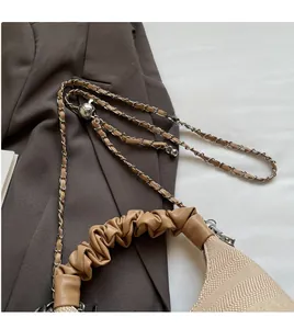 Detail of adjustable metal ball on a leather chain strap for crossbody bag