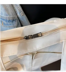 Detail of smooth metal zipper closure and interior pocket on white canvas tote bag