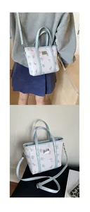 Detail of light blue bucket bag with cartoon bear and rabbit prints and adjustable strap