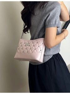Pink quilted shoulder bag with rhinestone star and silver chain strap shown on model