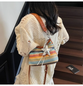 Détail d'un sac bandoulière en paille tissée avec sangle en cuir et pendentif étoile