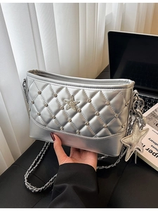 Silver quilted bucket bag with rhinestone studs and star charm in an urban lifestyle setting