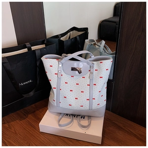 Detail view of floral tote bag with red bow patterns and heart-shaped metal lock