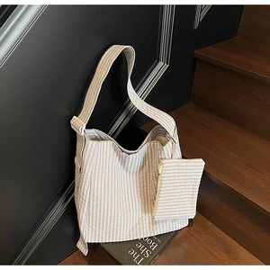 Detail of checkered tote bag and matching pouch on a rustic wooden staircase