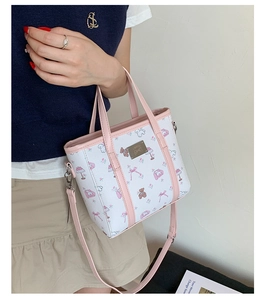 Close-up of pink bear print tote bag with adjustable shoulder strap and metal logo