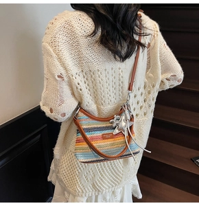Détail d'un sac hobo tissé coloré avec lanières en cuir et breloque étoile argent