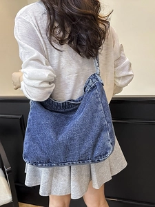Borsa a tracolla in denim retrò con dettagli sfrangiati indossata da modella donna