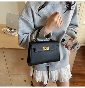 Classic black litchi pattern leather handbag with metal turn-lock and crossbody strap