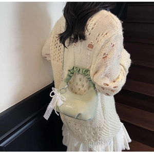Sage green dumpling bag with lace bow and pearl pendant shown on a model's arm