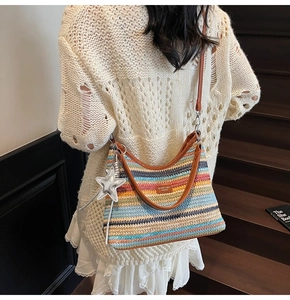 Détail du sac hobo en paille tressée arc-en-ciel avec anses en cuir brun et breloque étoile