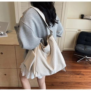 Detail view of large cream tote bag with waffle texture and detachable small pouch