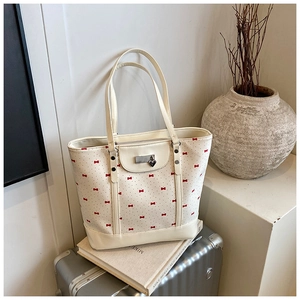 Detail of floral tote bag with heart charm and silver trunk in elegant setting