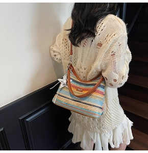 Détail d'un sac de plage tissé à rayures colorées avec des lanières en cuir marron