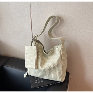 Detailed view of sage green textured tote bag with matching mini pouch and wide strap
