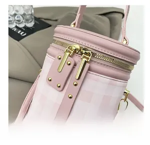Close-up of pink bucket bag featuring smooth double golden zippers and metal rivets