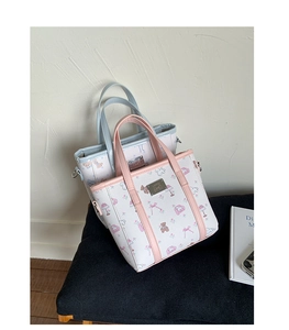 Close-up of small tote bags with cartoon bear prints and luxury lychee leather texture