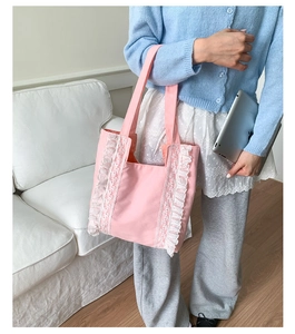 Close-up of pink canvas tote bag featuring intricate white lace trim and pleated details