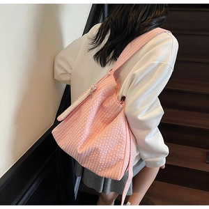 Detailed view of pink gingham tote bag with wide strap and zip closure on stairs