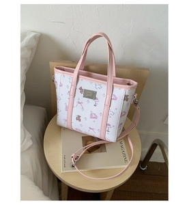 Detail of pink and white floral tote bag with cute animal prints on a wooden table
