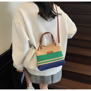 Detail of a knit color-block crossbody bucket bag with leather handles and logo patch