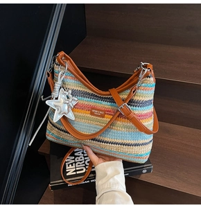 Détail du sac de plage tissé coloré avec bandoulière en cuir et breloques argentées