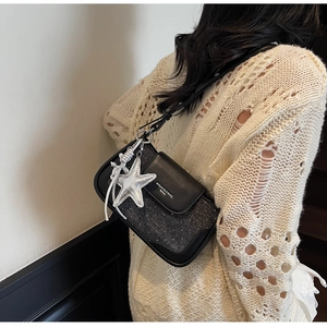 Detail of crossbody bag with blue denim patchwork and silver starfish charm