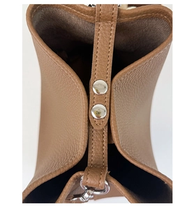 Close-up of brown pebbled leather bucket bag with silver metal snap buttons and neat stitching