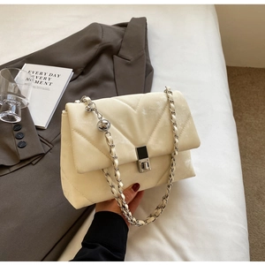 Close-up of cream white crossbody bag with V-quilted texture and silver chain