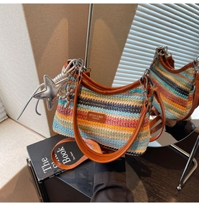 Détail d'un sac de plage tissé à rayures colorées avec anse en cuir marron et breloque étoile