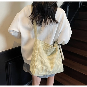Green checkered tote bag in waffle texture fabric shown on model in a casual setting